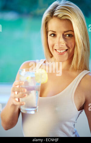 Mädchen trinken Glas Eiswasser mit Zitrone Stockfoto