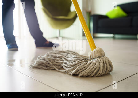 Frau zu Hause, tun Hausarbeiten und Hauswirtschaft, wischte Boden mit Wasser im Wohnzimmer. Konzentrieren Sie sich auf Boden und mop Stockfoto