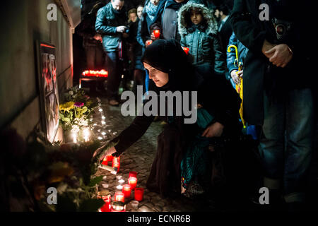 Berlin, Deutschland. 17. Dezember 2014. Eine Frau zündet eine Kerze während eine Mahnwache an der pakistanischen Botschaft in Berlin, Deutschland, 17. Dezember 2014. Im Hinblick auf die Opfer des Angriffs in der pakistanischen Stadt Peshawar einen Tag früher. Foto: GREGOR FISCHER/Dpa/Alamy Live News Stockfoto