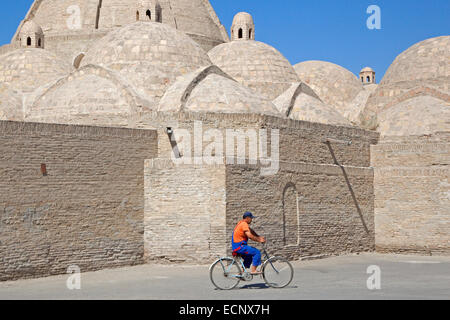 Usbekische Mann Radfahren vor Moschee in der alten historischen Stadt Buchara / Buxoro, Usbekistan Stockfoto