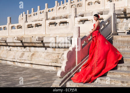 Junge Braut im roten Brautkleid vor der Himmelstempel in Peking, China Stockfoto