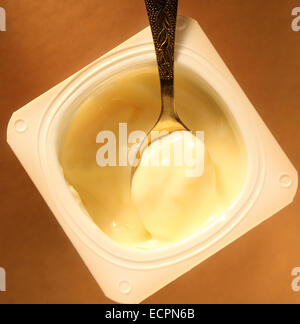 Joghurt-Topf mit vollen Löffel in Nahaufnahme Stockfoto