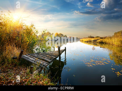 Alten Pier auf Herbst Fluss bei Sonnenuntergang Stockfoto