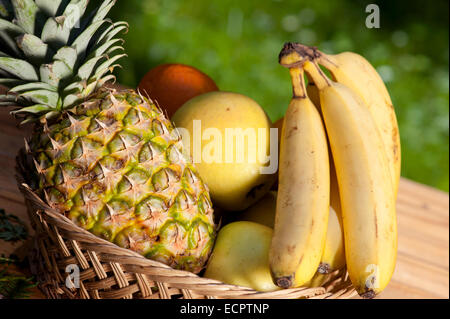 Obstkorb mit Äpfeln, Ananas und Bananen Stockfoto