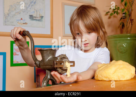 Junge Schleifen Teig in der Küche Stockfoto