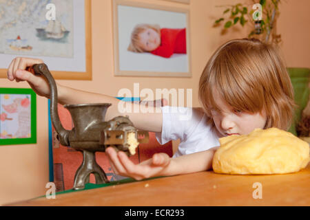 Junge Schleifen Teig in der Küche Stockfoto