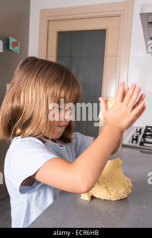 Kleine Mädchen, das Cookie-Teig zu Hause Stockfoto