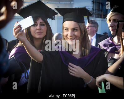 Zwei weibliche Absolventen nehmen eine Selfie vor der Abschlussfeier der Southampton Solent University in Guildhall Square. Stockfoto