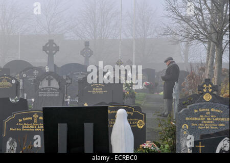 Mann, der betet in Nebel gehüllt Friedhof.  Foto © George Sweeney/Alamy Stockfoto