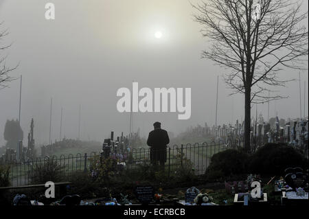 Mann, der betet in Nebel gehüllt Friedhof.  Foto © George Sweeney/Alamy Stockfoto