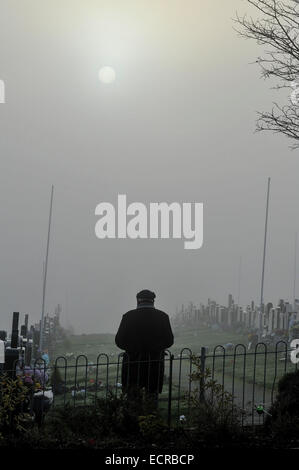 Mann, der betet in Nebel gehüllt Friedhof.  Foto © George Sweeney/Alamy Stockfoto