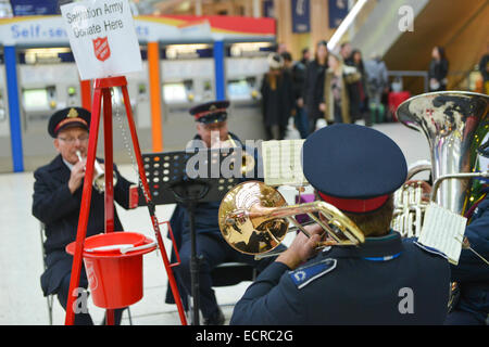 Waterloo Station, London, UK. 18. Dezember 2014. Die Heilsarmee-Brass-Band spielen Weihnachtslieder in Waterloo Station, neben dem Baum. Bildnachweis: Matthew Chattle/Alamy Live-Nachrichten Stockfoto