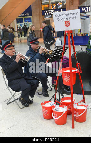 Waterloo Station, London, UK. 18. Dezember 2014. Die Heilsarmee-Brass-Band spielen Weihnachtslieder in Waterloo Station, neben dem Baum. Bildnachweis: Matthew Chattle/Alamy Live-Nachrichten Stockfoto