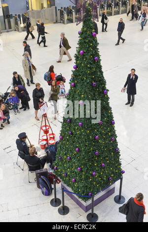 Waterloo Station, London, UK. 18. Dezember 2014. Die Heilsarmee-Brass-Band spielen Weihnachtslieder in Waterloo Station, neben dem Baum. Bildnachweis: Matthew Chattle/Alamy Live-Nachrichten Stockfoto