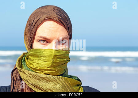 Schöne arabische Frau mit grünem Schal am Meer Stockfoto