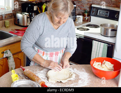 Ältere Frau oder Oma Vorbereitung Tortenboden in ihrer Küche Stockfoto