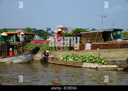 Anbieter am schwimmenden Markt, Can Tho, Vietnam, am Mekong-Delta, Wassermelonen auf kleineres Boot von einem größeren Boot laden Stockfoto