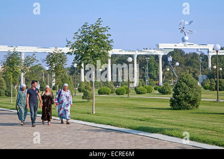 Usbekische Frauen in traditioneller Tracht, die zu Fuß durch Unabhängigkeitsplatz in Taschkent, Usbekistan Stockfoto