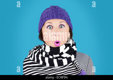 Lustig überrascht Gesicht Frau mit Hut und Streifen schwarz-weiß Wollschal: humorvolle Winter-Konzept Stockfoto