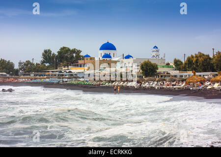 Stürmische See, Strand mit Liegestühlen und blaue Kuppel der griechisch-orthodoxen Kirche Stockfoto