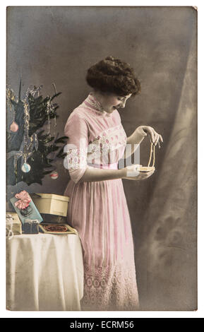 junge Frau mit Geschenken und Weihnachtsbaum. Vintage Bild mit original Kratzer, Filmkorn und Unschärfe Stockfoto