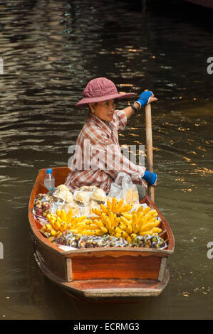 Vertikale Porträt einer Dame mit Obst in Damnoen Saduak Floating Market in Ratchaburi in der Nähe von Bangkok. Stockfoto