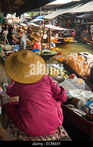 Vertikale Ansicht der Damen Verkauf von Produkten aus ihrer Holzboote in Damnoen Saduak Floating Market in Ratchaburi. Stockfoto