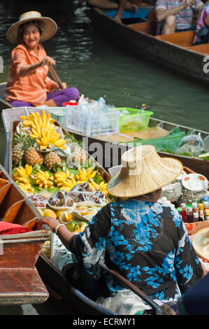 Vertikale Ansicht der Damen Verkauf von Produkten aus ihrer Holzboote in Damnoen Saduak Floating Market in Ratchaburi. Stockfoto