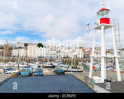 Ein Leuchtturm auf Albert Pier St Peter Port harbour Guernsey und Yachten in der Victoria Marina Stockfoto