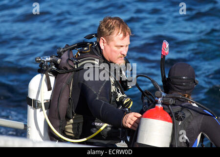 Tauchlehrer hilft seiner Schüler das Wasser in Avalon, Catalina Island, Kalifornien ein. Stockfoto