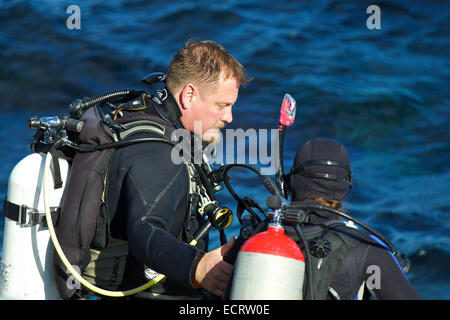 Tauchlehrer hilft seiner Schüler das Wasser in Avalon, Catalina Island, Kalifornien ein. Stockfoto