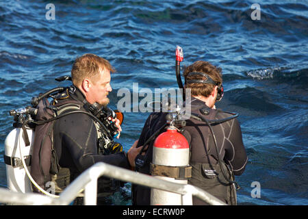 Tauchlehrer hilft seiner Schüler das Wasser in Avalon, Catalina Island, Kalifornien ein. Stockfoto