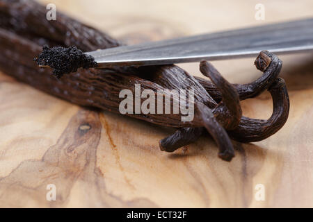 Vanilleschote auf Oliven Brett mit Bohnen auf Messer, Nahaufnahme Foto Stockfoto