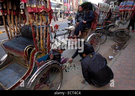 Nepali Männer spielen Schach inmitten Zyklus Rikschas in der Stadt Kathmandu in Nepal Stockfoto