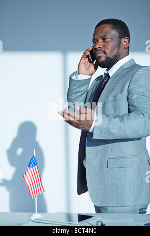 Ernsthafte Chef, die Mitarbeiter am Telefon sprechen Stockfoto