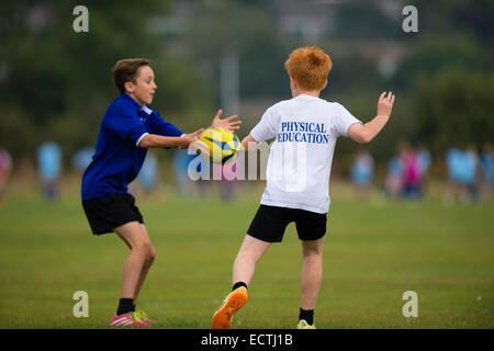 Mittelschule PE - Sportunterricht Wales UK: Spiele Lektion - jungen im Teenageralter den Ball spielen Rugby-Rugger im Freien auf Stellplatz Sportplatz Feld Stockfoto