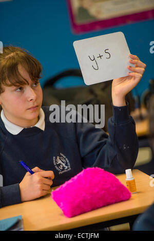 Mathematik Sekundarstufe Wales UK: eine Mädchen hält Karten, auf denen sie, die Antworten auf Algebra Probleme geschrieben hat, gesetzt durch den Lehrer Stockfoto