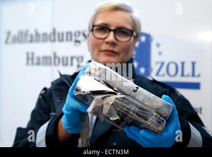 Hamburg, Deutschland. 18. Dezember 2014. Bianka Guelck, Sprecherin der das Hauptzollamt Hamburg-Hafen, hält ein Paket von Kokain in die Kamera bei der Zollstelle Untersuchungen in Hamburg, Deutschland, 18. Dezember 2014. Am vergangenen Sonntag fanden Zollbeamte 66 Kilogramm Kokain in Bananenkisten in einem Behälter aus Südamerika versteckt. Foto: Jörn Bangigkeit/Dpa/Alamy Live News Stockfoto