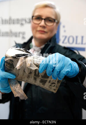 Hamburg, Deutschland. 18. Dezember 2014. Bianka Guelck, Sprecherin der das Hauptzollamt Hamburg-Hafen, hält ein Paket von Kokain in die Kamera bei der Zollstelle Untersuchungen in Hamburg, Deutschland, 18. Dezember 2014. Am vergangenen Sonntag fanden Zollbeamte 66 Kilogramm Kokain in Bananenkisten in einem Behälter aus Südamerika versteckt. Foto: Jörn Bangigkeit/Dpa/Alamy Live News Stockfoto