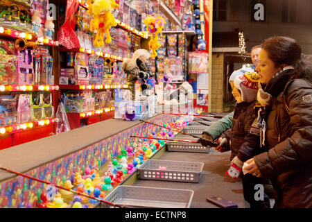 Eine Familie, die ein "Haken eine Ente" Spiel in einem Stall, Brügge Weihnachtsmarkt, Brügge, Belgien Stockfoto