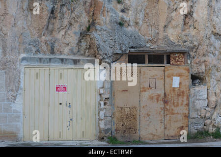 Garagen, die inmitten der Felswand in Malta Stockfoto