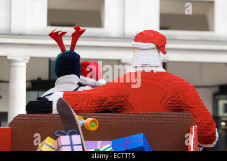 Touristen saß auf einem Lego Schlitten mit dem Weihnachtsmann von Lego hergestellt in Covent Gardens London England angezeigt Stockfoto