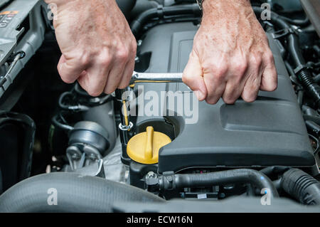 Hände, die Reparatur der Motor eines Autos mit einem Schraubenschlüssel Stockfoto