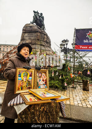 Kiew, Ukraine. 19. Dezember 2014. Frau verkauft gestickte Ikone auf Grund eines Denkmals für Bogdan Khmelnitsky--Weihnachtsmarkt auf dem Marktplatz in der Nähe von St. Sophia Credit: Igor Golovnov/Alamy Live News Stockfoto