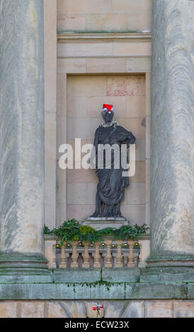 Führen Sie Statue von John Cheere einer Muse in einem steinernen Nischen und mit Santa Claus Hut und Lametta Stockfoto