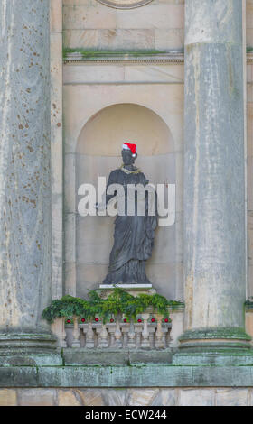 Führen Sie Statue von John Cheere einer Muse in einem steinernen Nischen und mit Santa Claus Hut und Lametta. Stockfoto