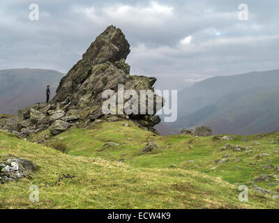 Hill-Walker bewundert "Haubitze" Felsformation auf dem Gipfel des Helm Crag, Grasmere, Lake District, Cumbria, England, UK. Stockfoto