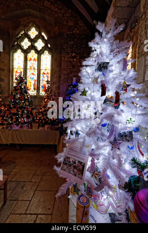 Weihnachtsbäume schmücken Teil des Kirchenschiffs von St. Marys Church, eingerichtet Brighstone, UK während des Festivals Christmas Tree Stockfoto