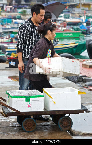 Chinesischer Mann und Frau Laden Fisch am Markt auf Cheung Chau Island, Hong Kong. Stockfoto