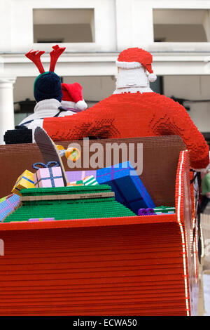 Touristen saß auf einem Lego Schlitten mit dem Weihnachtsmann von Lego hergestellt in Covent Gardens London England angezeigt Stockfoto
